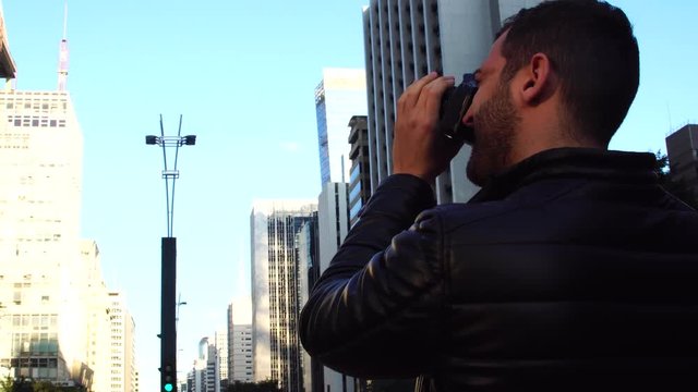 Young man photographing Paulista Avenue - Sao Paulo city, Brazil