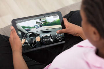 Girl Playing Car Race Game On Digital Tablet