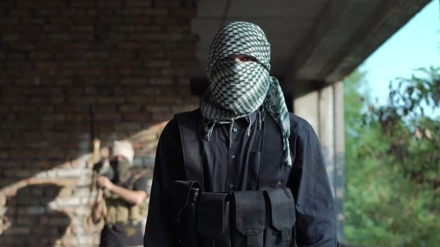 Terrorist with knife looking at camera and talking while delivering video message.