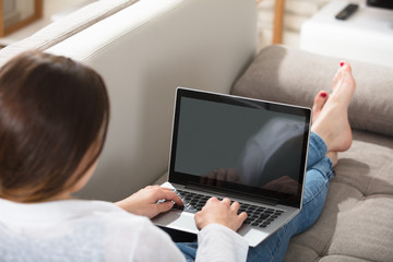 Woman On Couch Using Laptop