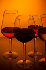 Set of wine glasses with red, white and rose wine on orange background close up