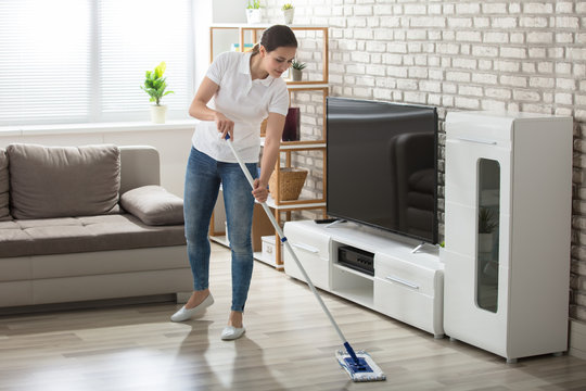 Young Woman Cleaning The Hardwood Floor