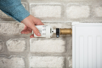 Person Adjusting Temperature Of Radiator