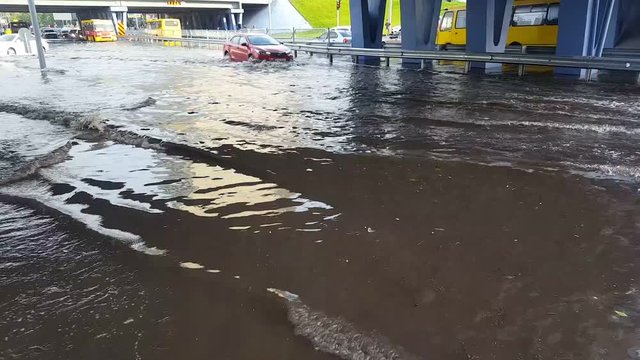 Flooding in the city. Cars are driving on a flooded road