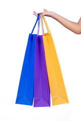 Child's hand holding colorful shopping bags