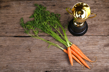 Carrots and gold trophy, concept of reward for achievement