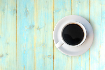 Cup of black coffee on wooden table, top view