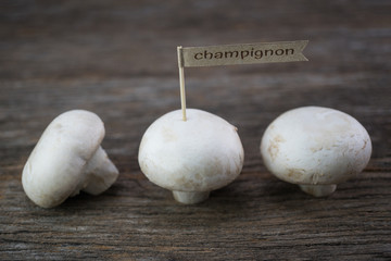Fresh organic champignon mushrooms on wood background