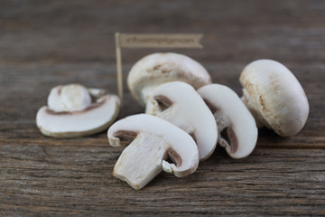 Fresh organic champignon mushrooms on wood background