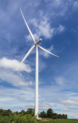 Fototapeta na wymiar white wind turbines generating electricity in wind power station under blue sky background 