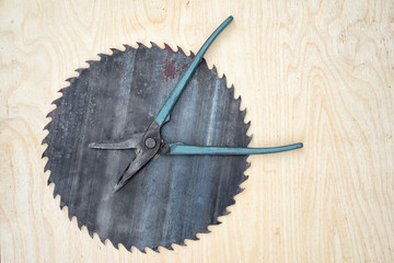 Conceptual image time to do repairs. Pliers as a clock hands and circular saw blade as a clock face...