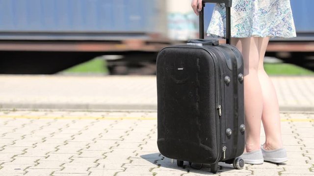 Person with suitcase waiting at platform for right train 4K