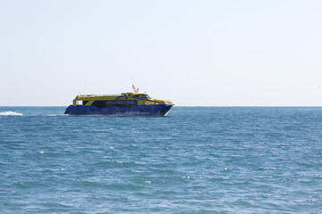 Big catamaran passenger ship going full speed ahead on the sea. Boat composed to the left.