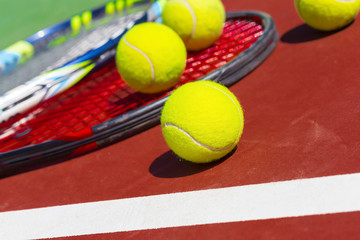 Tennis balls and racket on the grass court