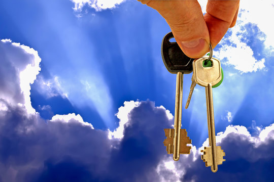 The keys to the apartment on the background of blue sky and clouds . The concept of new home sales .