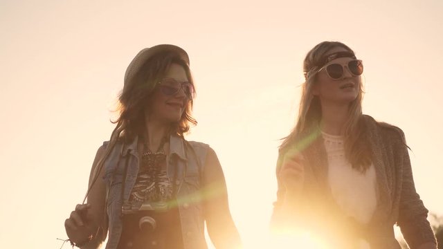 hippie girls are on the road at sunset and talking
