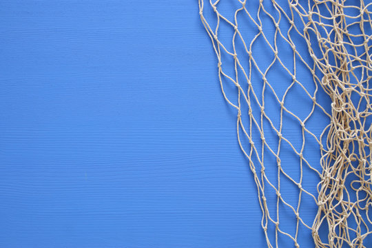 Top view of Fishnet on blue wooden background