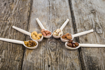 Nuts in a wooden spoons on a  wooden table.
