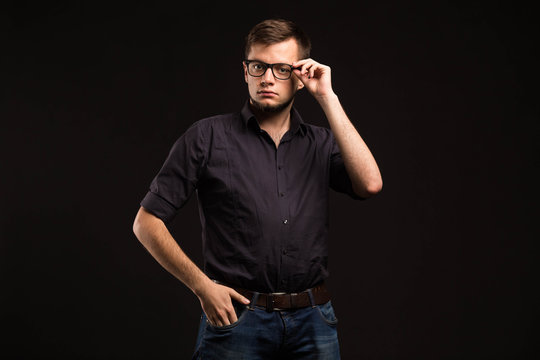 Young confident man portrait of a confident businessman on a black background. Ideal for banners, registration forms, presentation, landings, presenting concept.
