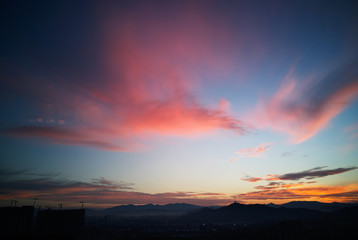 Fototapeta premium Beautiful natural sunset sunrise over silhouettes city skyline and amazing orange cloud blue sky above it .
