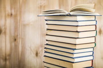 Stack of books on a wooden background.