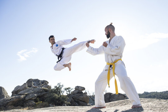Man doing a jump kick during a martial arts combat