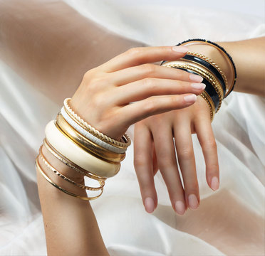 Girl’s hands with golden bracelets
