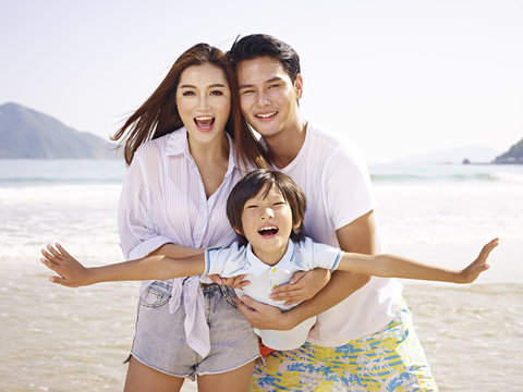 asian family having fun on beach