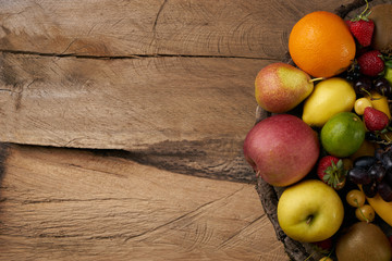 Top view of a fresh raw fruits. Mixed colorful fruits on wooden stump. Healthy eating, dieting, love fruit. Background with copy space.