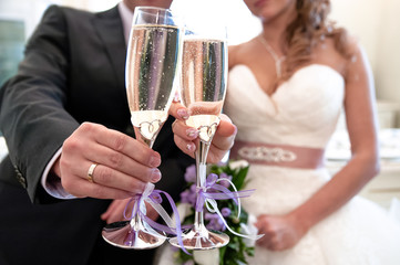 Glasses with champagne in the hands of the bride and groom. Macro