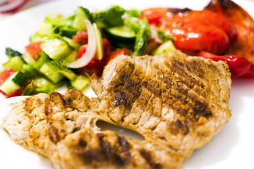 Fried meat on the grill. Fried meat on coals. Steak, fried vegetables, pepper