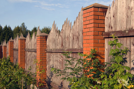 Wooden fence with red brick columns