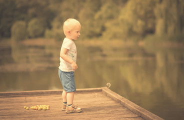 Little boy play with wild berries