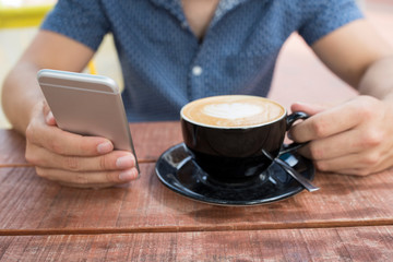 Close Up Of Man At Outdoor Cafe Texting On Mobile Phone