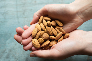 Close Up Of Woman Holding Handful Of Almonds