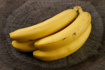 Bunch of bananas isolated on wooden background. Close up. Healthy eating concept.