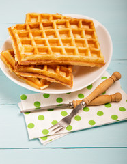 Freshly baked belgium waffles in plate. Breakfast concept with copy space on wooden background