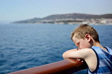 Sad thoughtful little boy looking at the sea