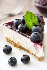 Piece of blueberry cheesecake on wooden table

