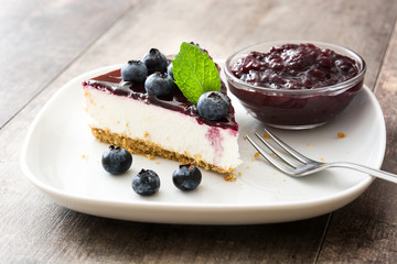 Piece of blueberry cheesecake on wooden table
