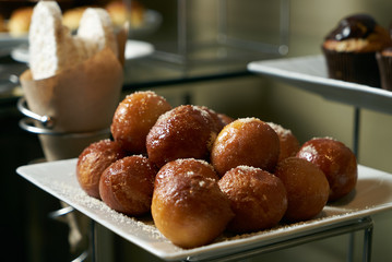 Homemade loukoumades donuts with honey and cinnamon close-up on a white plate