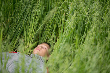 Happy boy young man on a green grain field