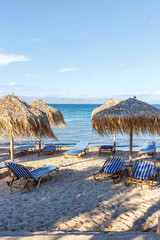 Corfu island beachside with chairs and umbrellas. Greece, sunset view