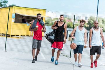 multiethnic group of athletic basketball players walking on court