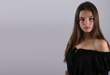 Naklejka premium Belle adolescente posant sur un fond gris 