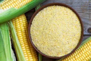 Organic maize flour in wooden bowl with fresh corn. Top view  © nedim_b