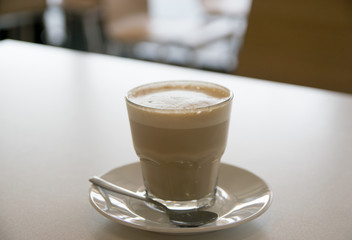 cup of coffee with milk over wooden table