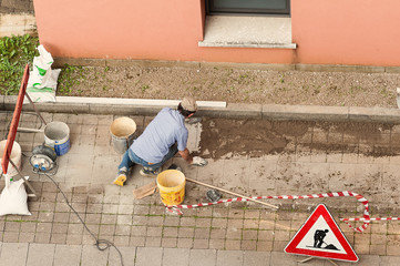 Bricklayer at work laying stone blocks.