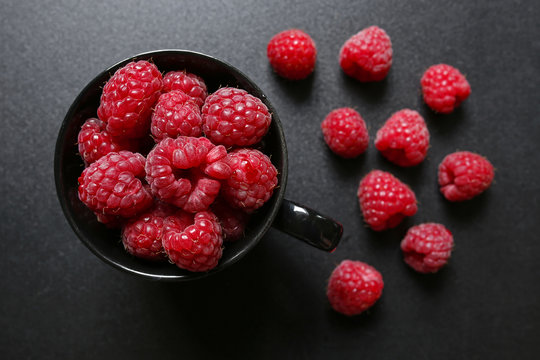 fresh raspberries in a black cup