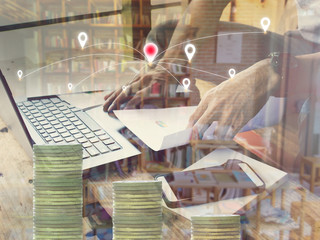 Double exposure of Businessmen use computers wiht blur library books and gold coins.financial graph